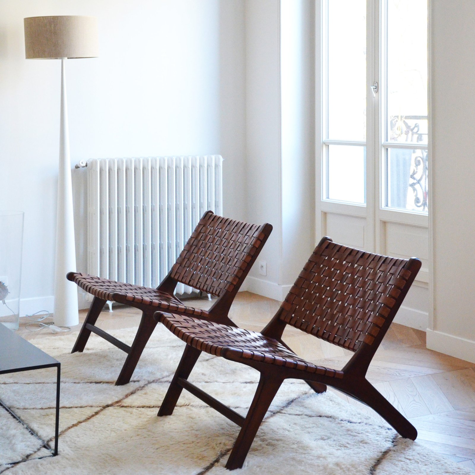 Deux fauteuils en bois marron dans un salon lumineux