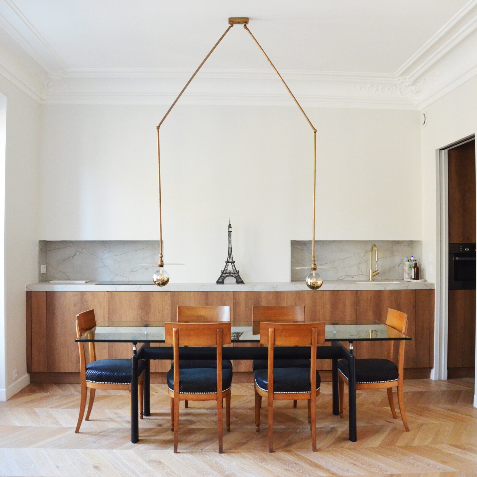 Salle à manger avec table verre, chaises bois et crédence marbre